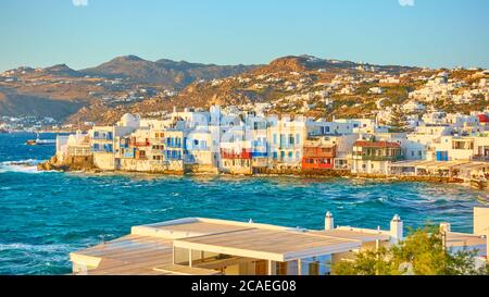 Panoramablick auf Mykonos Insel mit berühmten Häusern am Wasser bei Sonnenuntergang, Griechenland. Malerische griechische Landschaft Stockfoto