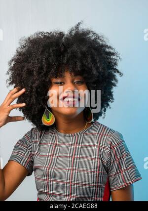 Schöne junge schwarze Frau, die sich um ihre Haare gefreut hat Stockfoto
