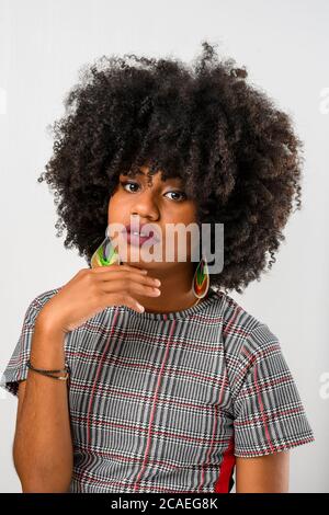 Junge schwarze Frau mit der Hand am Kinn und entspannt Stockfoto