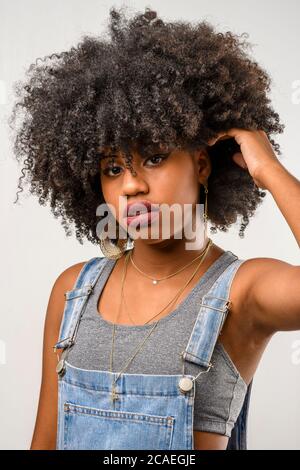 Schöne junge schwarze Frau, die sich um ihre Haare gefreut hat Stockfoto