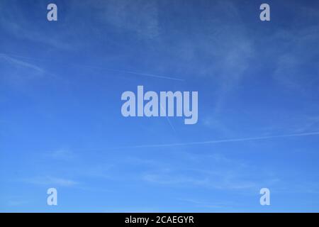 Wolken und Spuren von Flugzeugen am blauen Himmel. Feder. Stockfoto