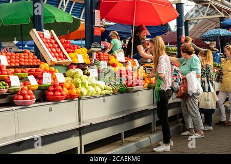 Käufer wählen frisches Gemüse an der Theke auf dem Markt. Stockfoto