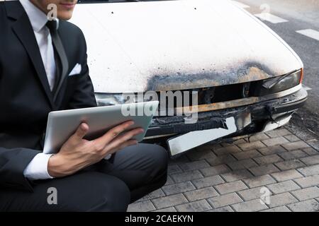 Versicherungsvertreter, Der Auto Nach Einem Feuerunfall Begeht Stockfoto