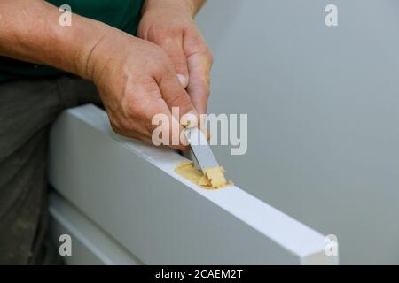 Die hölzerne Tür die Montage des Scharniers, das mit dem Meißel arbeitet, vorbereitet für die Montage auf den Scharnieren Stockfoto
