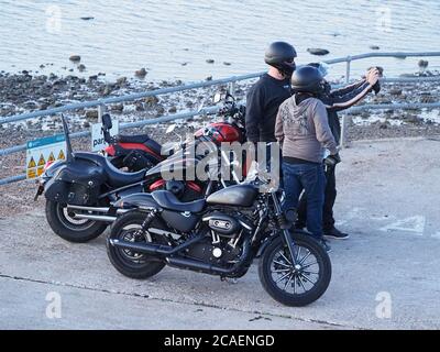 Sheerness, Kent, Großbritannien. August 2020. UK Wetter: Sonnenuntergang in Sheerness, Kent. Drei Biker machen ein Selfie mit dem Sonnenuntergang. Kredit: James Bell/Alamy Live Nachrichten Stockfoto