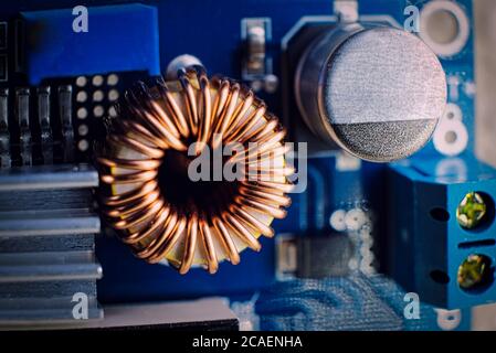 Ferrit Induktivitätsspule auf der Platine mit Kupferdraht zusammen mit anderen Komponenten, Makroaufnahme umwickelt Stockfoto