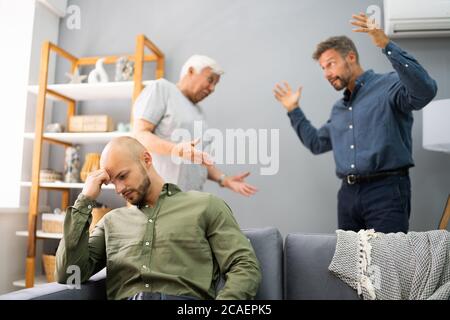 Großvater Mit Konflikt Mit Vater, Während Traurige Sohn Auf Der Couch Sitzen Stockfoto