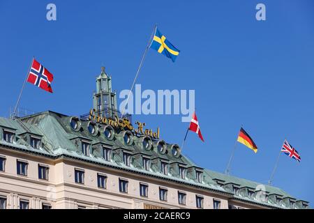 Stockholm, Schweden - 31. Juli 2020: Die obersten Etagen des Grand Hotels mit seinen histen Flaggen, die Norwegen, Schweden, Dänemark, Deutschland und Great Bbrücke repräsentieren Stockfoto