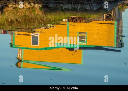 Haus im Dorf spiegelt sich im Hafen, Margaree, Neufundland und Labrador NL, Kanada Stockfoto