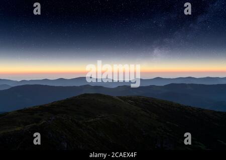 Die Berge liegen vor der Kulisse eines unglaublichen Sternenhimmels. Erstaunliche Nachtlandschaft mit Milchstraße. Tourismuskonzept Stockfoto