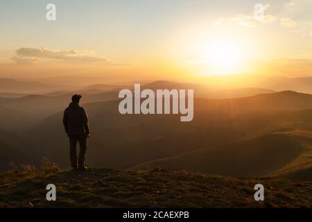 Allein Tourist am Rande der Klippe vor der Kulisse einer unglaublichen Sonnenuntergang Berglandschaft Stockfoto