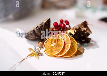 Auf weißem Hintergrund sind Details, getrocknete Orangen, Zweige und Beeren zur Dekoration, Stockfoto