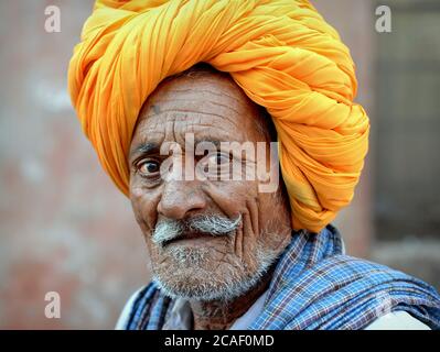 PLD Indian Rajasthani Rabari Mann mit gelben traditionellen Rajasthani Turban (Pagari) Posen für die Kamera. Stockfoto