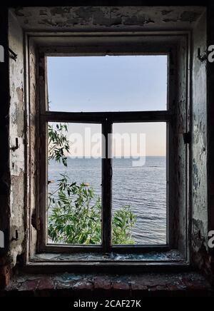 Blick aus dem Fenster des Hauses auf den Hintergrund des Meeres Stockfoto