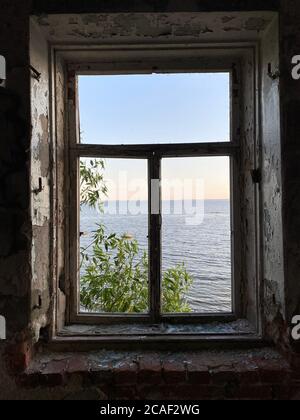 Blick aus dem Fenster des Hauses auf den Hintergrund des Meeres Stockfoto