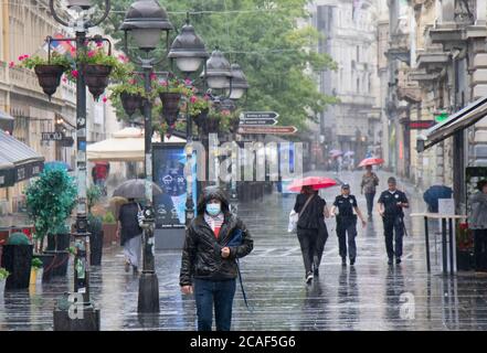 Belgrad, Serbien - 5. August 2020: Menschen gehen an einem regnerischen Sommertag in der Stadt auf der Knez Mihailova Fußgängerzone Stockfoto