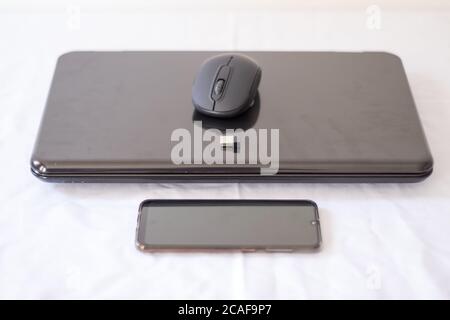 Laptop und Handy auf weißem Hintergrund Stockfoto