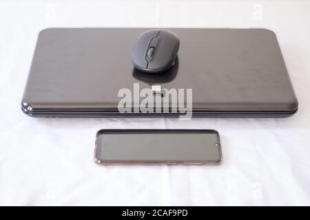Laptop und Handy auf weißem Hintergrund Stockfoto
