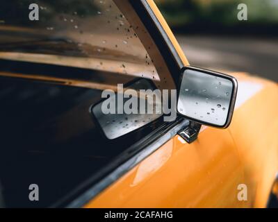 Nahaufnahme eines Seitenspiegels eines Vintage-Yellow Auto Stockfoto