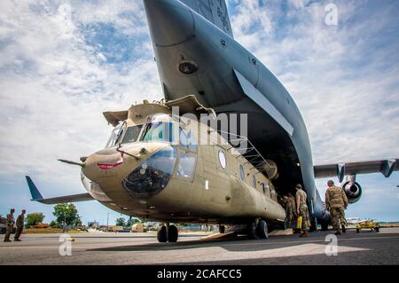 Soldaten der Connecticut National Guard entladen einen CH-47 Chinook Hubschrauber des 2nd Battalion, 104th Aviation Regiment von einer Alaska National Guard C-17 Globemaster in der Army Aviation Support Facility in Windsor Locks, Connecticut 6. August 2020. Die 2-104. Hat kürzlich einen erweiterten Einsatz in Afghanistan zur Unterstützung der Operation Freedom Sentinel abgeschlossen. Stockfoto