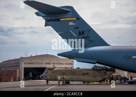 Soldaten der Connecticut National Guard entladen einen CH-47 Chinook Hubschrauber des 2nd Battalion, 104th Aviation Regiment von einer Alaska National Guard C-17 Globemaster in der Army Aviation Support Facility in Windsor Locks, Connecticut 6. August 2020. Die 2-104. Hat kürzlich einen erweiterten Einsatz in Afghanistan zur Unterstützung der Operation Freedom Sentinel abgeschlossen. Stockfoto