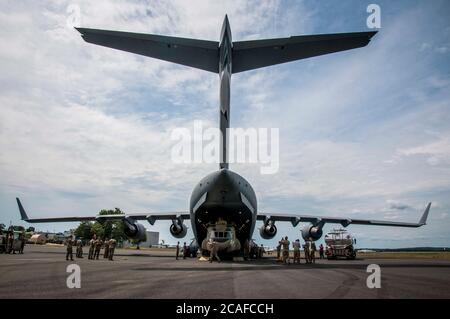 Soldaten der Connecticut National Guard entladen einen CH-47 Chinook Hubschrauber des 2nd Battalion, 104th Aviation Regiment von einer Alaska National Guard C-17 Globemaster in der Army Aviation Support Facility in Windsor Locks, Connecticut 6. August 2020. Die 2-104. Hat kürzlich einen erweiterten Einsatz in Afghanistan zur Unterstützung der Operation Freedom Sentinel abgeschlossen. Stockfoto