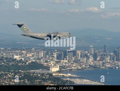 Ein C-17 Globemaster III von Joint Base Lewis-McChord fliegt über die Skyline von Seattle, nachdem er am 5. August 2020 eine Low-Level-Formationstraining-Übung im Zentrum von Washington absolviert hat. Das Fliegen in einer Formation von zwei oder mehr Flugzeugen in einem Kampfszenario ermöglicht taktischen Vorteil, indem es gegenseitige Unterstützung und Masse der Flugzeuge über einem objektiven Gebiet festlegt. (USA Luftwaffe Foto von Airman 1st Class Mikayla Heineck) Stockfoto