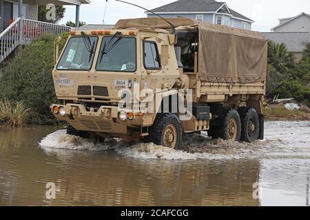 Fahrzeuge, die der 878th Engineer Vertical Construction Company, 105th Engineer Bataillon, zugewiesen wurden, fahren auf dem Weg durch überflutete Straßen und Schutt, um gestrandeten Zivilisten auf Oak Island, North Carolina, zu helfen, 5. August 2020. Die North Carolina National Guard entsetzte Teams im gesamten östlichen Teil des Staates, um Zivilisten und North Carolina Emergency Management bei Schäden durch Hurrikan Isaias zu unterstützen. (USA Army National Guard Foto von Sgt. Lisa Vines, 382nd Public Affairs Detachment/Freigegeben) (USA Army National Guard Foto von Sgt. Lisa Vines, 382. Abteilung für öffentliche Angelegenheiten/freigelassen) Stockfoto