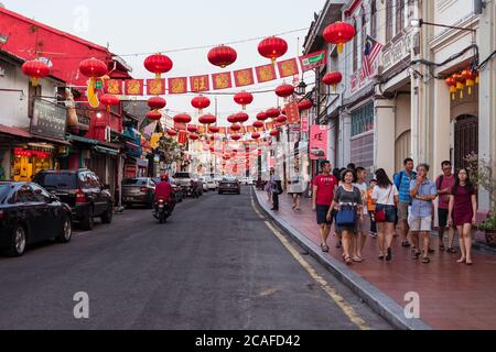 Malacca / Malaysia - 16. Februar 2019: Gruppe von Touristen, die während der chinesischen Neujahrsfeiern durch die Straßen von Malacca schlendern und rote Laternen über der Straße hängen Stockfoto