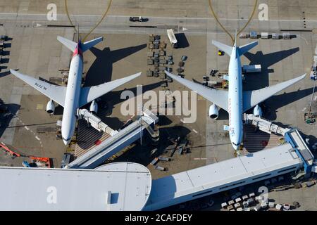 Zwei Boeing 777 parkten am internationalen Terminal 1 des Kingsford Smith Airport in NSW, Australien. Flugzeuge, die mit Düsenbrücken verbunden sind. Stockfoto