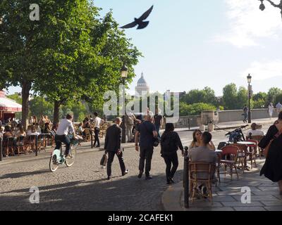 Paris, Frankreich. Juli 2020. Touristen und Einheimische genießen einen sonnigen Abend auf dem Île Saint Louis im Herzen der französischen Hauptstadt. Im Hintergrund sieht man den Panthéon. Paris ist derzeit so leer wie selten zuvor. Wer die Metropole besucht, muss nicht in endlosen Schlangen warten. Doch für die Tourismusbranche sind die Folgen der Corona-Krise katastrophal. (To dpa 'nur auf den Eiffelturm gehen - Urlaub in Paris in Zeiten von Corona') Quelle: Christian Böhmer/dpa/Alamy Live News Stockfoto