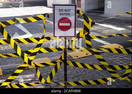 17.07.2020, Singapur, Republik Singapur, Asien - EIN abgesperrter Eingang mit einem Verbotsschild und schwarz-gelbem Sperrband. Stockfoto