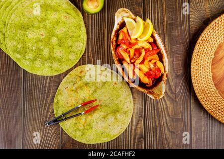 Spinat Wrap mit Rühren braten Huhn und Gemüse auf Holzgrund. Stockfoto