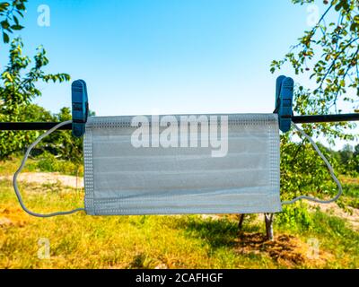 Die medizinische Gesichtsmaske trocknet auf einer Wäscheleine. Stockfoto