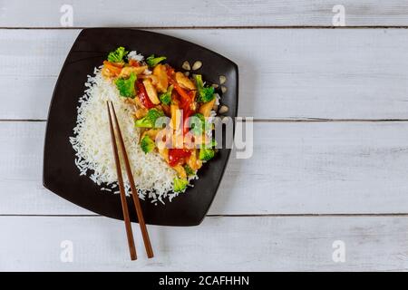 Asiatische rühren braten Fleisch, Gemüse mit weißem Reis und Essstäbchen. Stockfoto