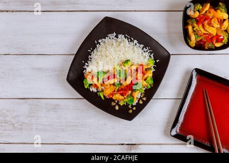 Asiatische rühren braten Fleisch, Gemüse mit weißem Reis und Essstäbchen. Stockfoto