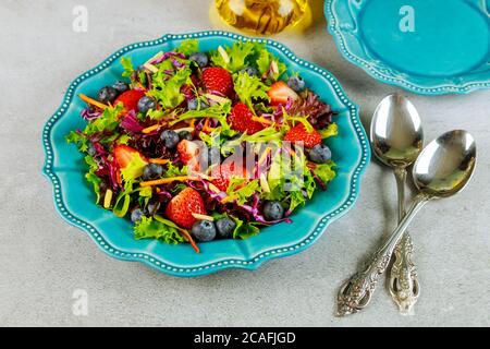 Grüner Salat mit Salat, Spinat, Rotkohl und Beeren. Stockfoto