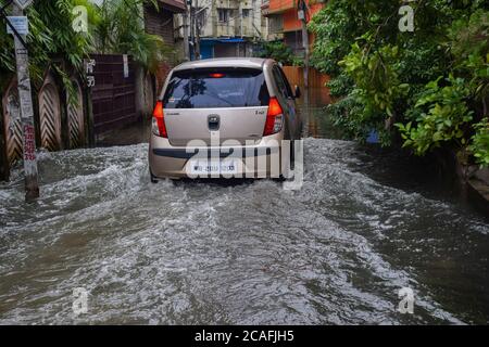 Kalkutta, Indien. August 2020. Ein Auto fährt durch eine überflutete Straße nach dem Regen.mehrere Gebiete sind durch den späten Nachtregen in Kalkutta, der das tägliche Leben der Menschen sehr schlecht beeinflusst, vor allem, um durch die Stadt zu pendeln. Kredit: SOPA Images Limited/Alamy Live Nachrichten Stockfoto