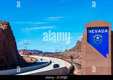 Willkommen bei Nevada Denkmal Schild an der Autobahn 11. Der Betonsockel mit versenkter State Silhouette mit auffälligen weißen Schriftzügen und dem Nevada Wappen Stockfoto