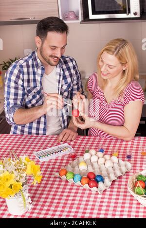 Schönes Paar lächelt und malt die ostereier Stockfoto