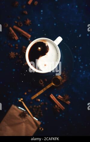 Yin-Yang-Symbol in einer Kaffeetasse mit Milch und Kaffeetropfen, ausgewogenes Geschmackskonzept, kreatives Stillleben Stockfoto