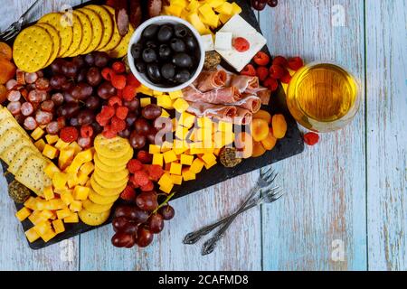 Wurstwaren, Käse, Oliven, Obst, Prosciutto und Wein auf Holztisch. Stockfoto