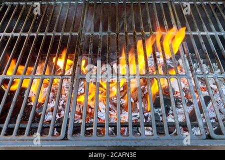 Flammen geht durch Gitter von Grill mit Holzkohle. Stockfoto