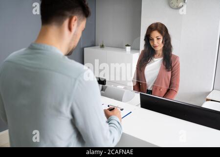 Kunde Unterzeichnet Rechnung An Der Rezeption Des Hotels Stockfoto