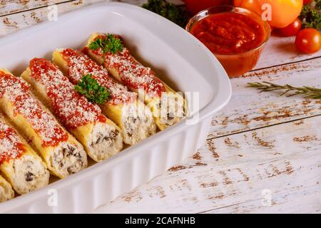 Cannelloni Pasta gefüllt mit Ricotta, Champignons und Tomatensauce in der Backform. Stockfoto