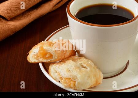 Mini Apfelstrudel auf der Untertasse einer Tasse Kaffee Stockfoto