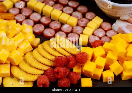 Fußballball aus Wurst und Käsewürfel auf Wurstbrett für american Football Game Party. Stockfoto