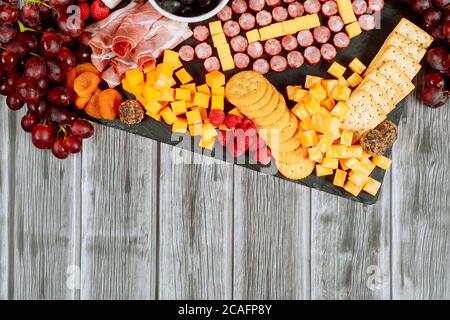 Fußball aus Käse und Wurst für Wurstwaren auf Holzhintergrund. American Football Spiel Konzept. Stockfoto