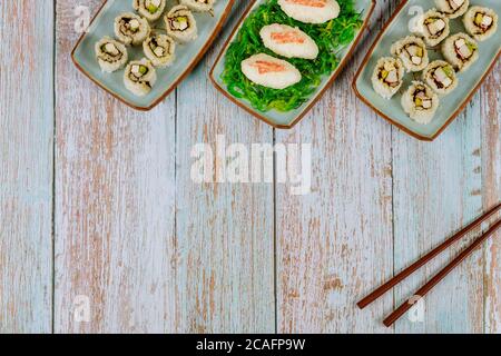 Leckeres Sushi und Brötchen mit Essstäbchen für Party. Japanisches Gericht. Stockfoto