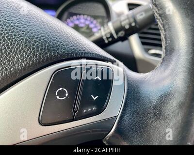 Modernes schwarzes Lenkrad mit Multifunktionstasten für schnelle Steuerung, Nahaufnahme im Auto. Stockfoto